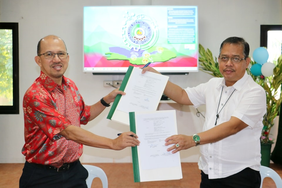 SEARCA Director Dr. Glenn B. Gregorio (left) and LSPU President Dr. Mario R. Briones, exchange copies of the MOU between SEARCA and LSPU signed on 17 December 2020.