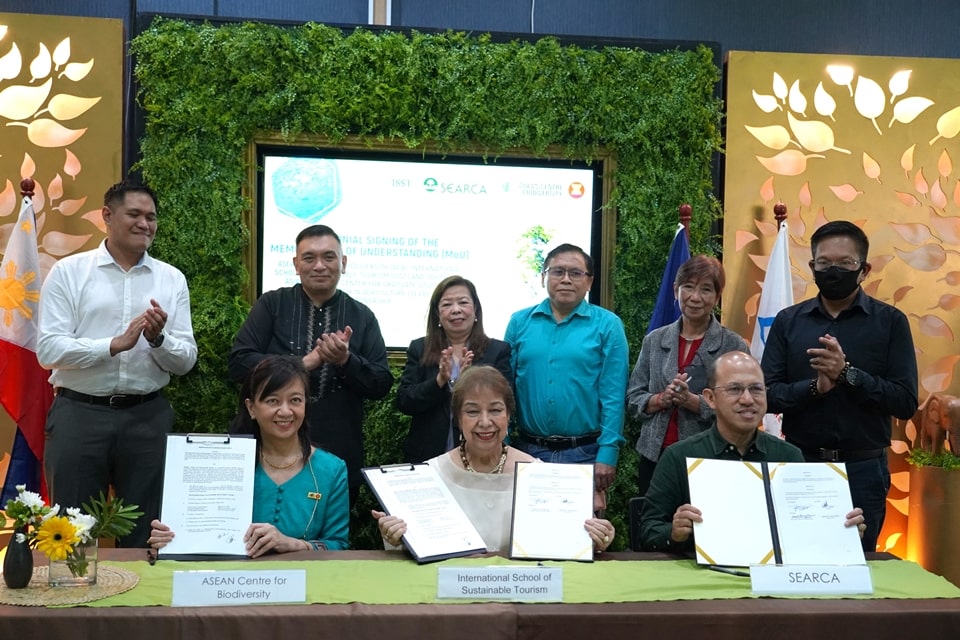 Dr. Mina T. Gabor (seated center), ISST President, signs agreements with Dr. Glenn B. Gregorio (seated rightmost), SEARCA Director, and Dr. Theresa Mundita S. Lim (seated leftmost), ACB Executive Director, as the respective witnesses standing at the back claps on.