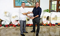 Dr. Dyball as he hands the book, [i]Understanding Human Ecology[/i], to Dr. Saguiguit.