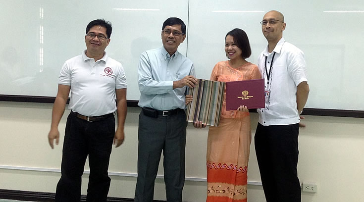 Ms. Su Latt Phyu receives her completion certificate from (L-R) Dr. Willie Abasolo, Dr. Felino Lansigan and Dr. Marish Madlangbayan during the Intensive English Course closing program on 1 December 2014.