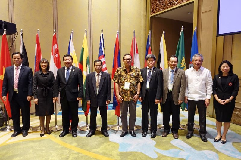 SEARCA GB members stood behind their country flags. From left to right:  Dr. Tran Van Dien, Rector of the Thai Nguyen University of Agriculture and Forestry, Vietnam; Mrs. Kanittha Duangpattra representing Dr. Sathit Puttachaiyong, President of Rajamangala University of Technology Krungthep, Thailand; Dr. Fernando C. Sanchez, Jr., Chancellor of the University of the Philippines Los Baños (UPLB) and Chair of the 64th GBM; Dr. Somphong Chanthavong, Acting Dean of Agriculture and Environment at Savannakhet University, Lao PDR; Dr. Ocky Karna Radjasa, Director, Strengthening Research and Development, Ministry of Research, Technology, and Higher Education, Indonesia; Dr. Ngo Bunthan, Rector of the Royal University of Agriculture (RUA), Cambodia; Dr. Haji Mohd Zamri Bin Haji Sabli, Assistant Director of the Institute of Brunei Technical Education, Ministry of Education, Brunei Darussalam; Dr. Gil C. Saguiguit, Jr., SEARCA Director, and Dr. Tinsiri Siribodhi, SEAMES Deputy Director for Administration and Communication, both ex-officio members of the SEARCA GBM.